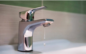 Bathroom faucet dripping water into a sink – Bomba Plumbers tap-leak repair service.